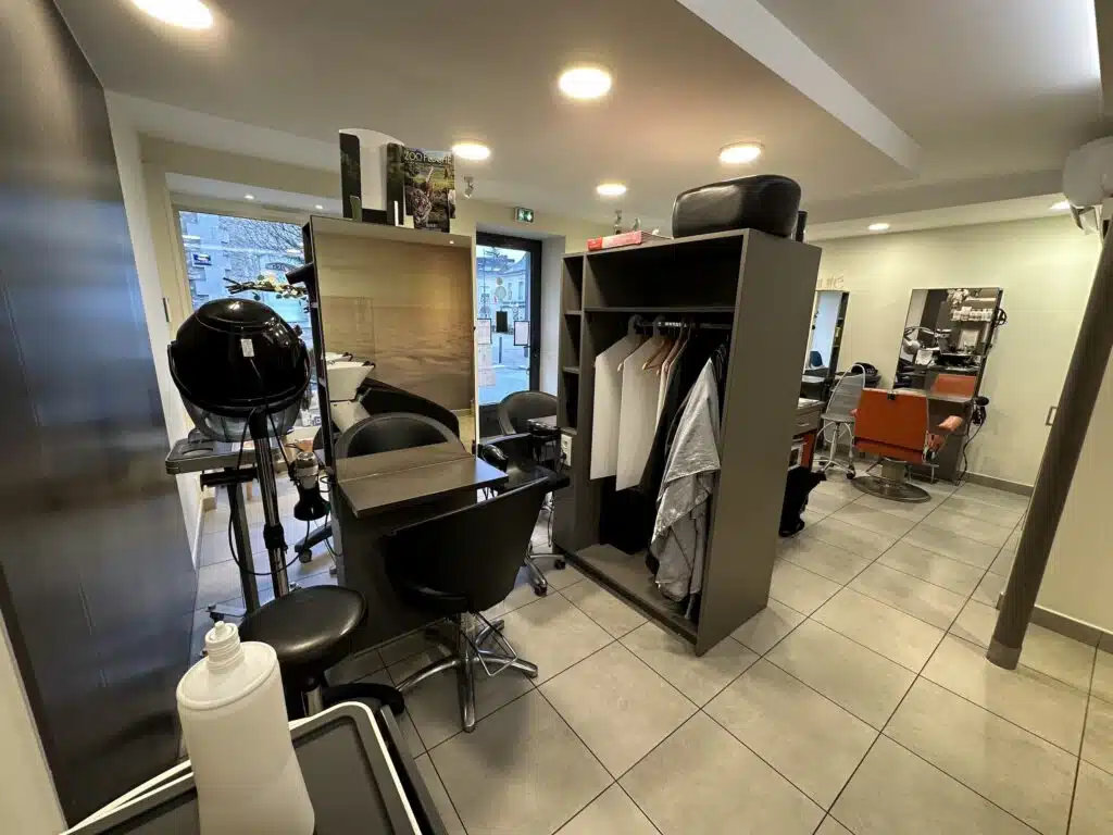 Un poste de coiffage côté bac à Shampoing et vestiaire du salon Expression Coiffure à Noyen-sur-Sarthe.